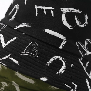 Close-up of graffiti print on black canvas bucket hat showing detailed stitching
