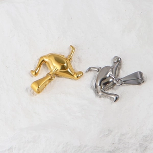 Close-up of human torso pendants in gold and silver finish on white plush background