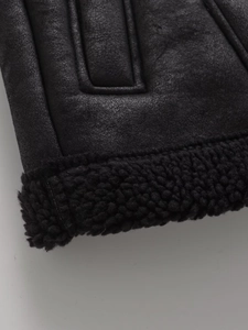 Gros plan sur le similicuir noir et la doublure en peau de mouton d'un gilet d'hiver