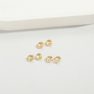 Three pairs of gold small star earrings with pink green and white smiley face charms