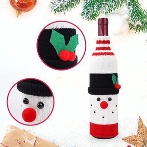 Macro detail of snowman knitted wine bottle cover with felt leaves and red pom pom