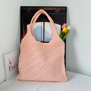 Close-up of pink knitted hollow pattern and wide shoulder strap on a large tote bag