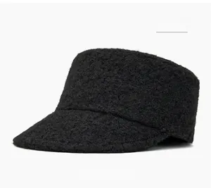 Close-up of black fuzzy wool flat top newsboy hat with textured bouclé fabric finish