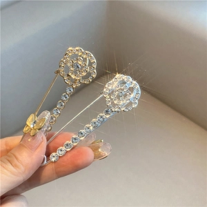 Detail of rose and butterfly waist pins with gold plating and cubic zirconia inlay