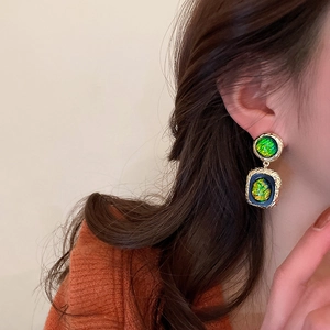 Vintage gold resin geometric drop earrings with green shell texture on model