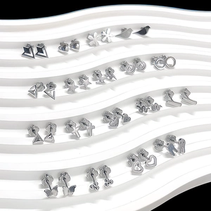 Macro shot of silver stainless steel earring set with butterfly and heart shapes