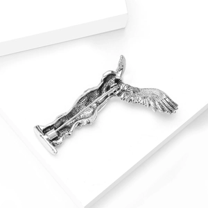 Macro shot of silver winged goddess brooch back showing needle pin and metal texture