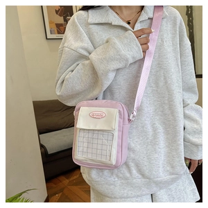 Détail du sac à bandoulière rose et blanc avec fenêtre à carreaux et sangle