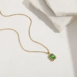 Macro detail of rectangle green emerald zircon pendant on gold chain necklace