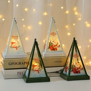 Close-up of pyramid Christmas lanterns with Santa and Snowman prints on vintage books