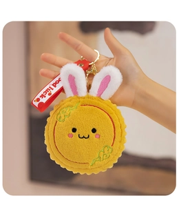 Detailed plush moon rabbit keychain with yellow faux fur, bunny ears and red Good Luck strap