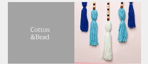 Detailed close-up of handmade cotton tassels and natural wooden beads for wall hanging decor
