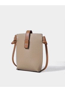 Detailed macro view of the lychee texture and buckle on the beige leather phone bag