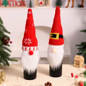 Detail of Christmas elf wine bottle covers with knitted red hats and faux fur beards