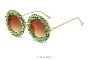Side view of round sunglasses with emerald green crystals and gold metal temples