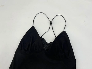 Detailed close-up of V-neckline with black lace trim on a slim-fit camisole dress