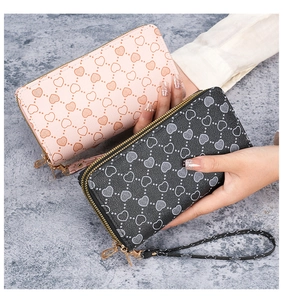 Detailed view of long double-zipper wallets in pink and black with heart prints