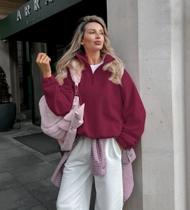 Oversized burgundy fleece sweatshirt for women with zipper collar in a street style view