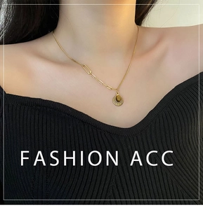 Detail of tiger eye stone pendant with gold sunburst pattern on asymmetric chain