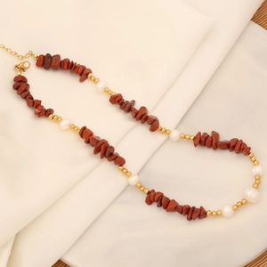 Detail of necklace with reddish-brown natural stones, white pearls and gold beads
