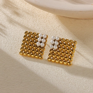 Detail of square gold stud earrings with intricate metal beads and pearl accents