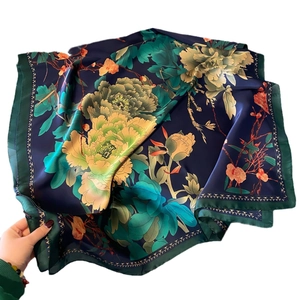 Lustrous dark blue silk-like scarf featuring elegant peony prints and gold trim borders