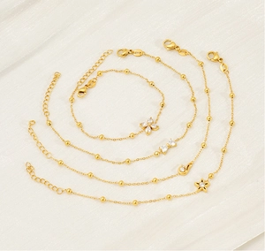 Detail showing gold bracelets with clover, bow, swan and star charms with zircon