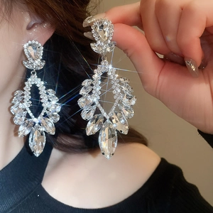 Gros plan sur les boucles d'oreilles pendantes en cristal et diamants argentés brillants