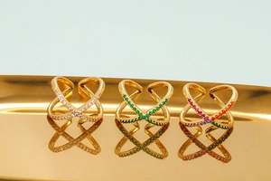 Detailed close-up of three crisscross rings with white green and multi-color zircon stones