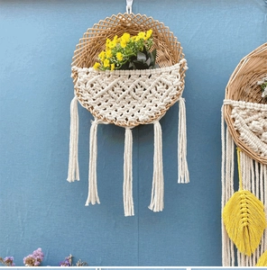 Detail eines Makramee-Wandkorbs im Boho-Stil mit Weidengeflecht und Baumwollquasten
