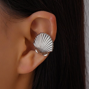 Close-up of silver shell ear cuff featuring radiating textures on a model's ear