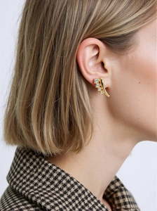 Detail of gold curved earrings with four graduated round diamonds on a female model