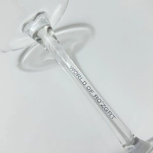 Macro shot of glass stem with black WORLD OF RO'ZGRT text on elegant shell wine cup