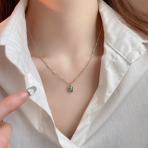 Detail view of Bohemian gold necklace with turquoise beads on model neck
