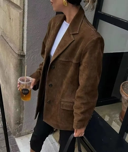 Close-up of vintage brown suede blazer with lapel collar and flap pockets detail