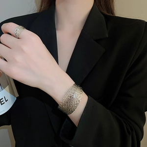 Detailed view of silver layered metal cuff bracelet and matching ring set on model