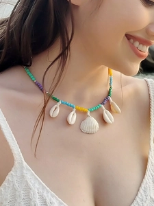 Detail of bohemian shell necklace with colorful beads on a model for beach vacation wear