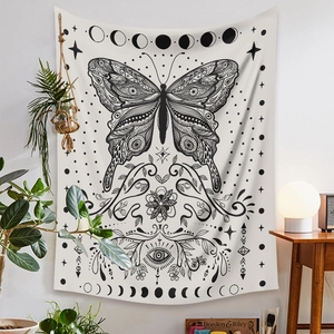 Detail of bohemian black and white butterfly tapestry on a wall with cozy warm lighting