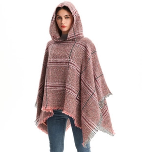Close-up of fringe details on a red plaid knit hooded poncho for women's winter wear