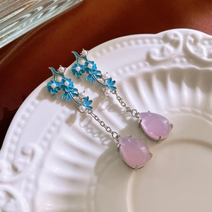 Detail of vintage silver earrings with blue flowers, pearls and pink drop gems