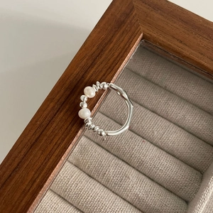 Detailed shot of S925 silver beaded ring with freshwater pearls on a wooden display