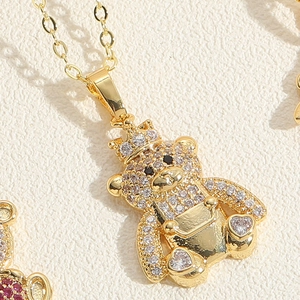Detail of a gold bear pendant with white zircon stones and crown for a necklace