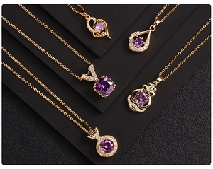 Close-up of gold-plated necklaces with purple zircon heart and water-drop pendants