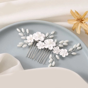 Detail of handmade bridal hair comb with white fabric flowers and faux pearls on silver wire