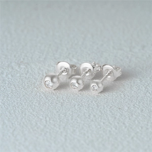 Macro shot of three sparkling silver s925 stud earrings with clear zircon stones set