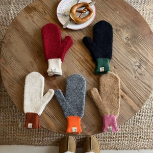 Vista plana de guantes de punto de invierno coloridos con función táctil en la mesa