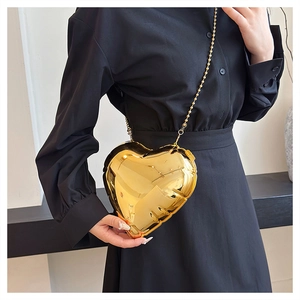 Golden balloon-style heart chain bag featuring metallic hard shell and bead strap