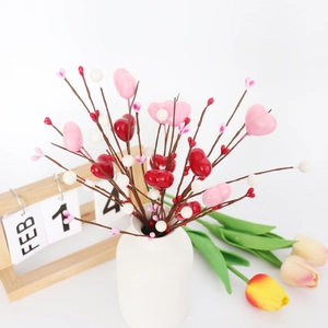 Tiges décoratives Saint-Valentin avec cœurs rouges roses dans un vase en céramique