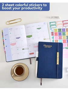 Flat lay of 2026-2027 blue faux leather planner with functional color stickers on a desk