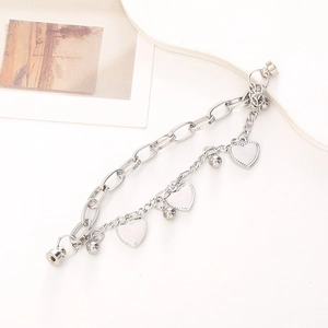 Silver metal double chain bracelet with heart charms and magnetic clasp on white background